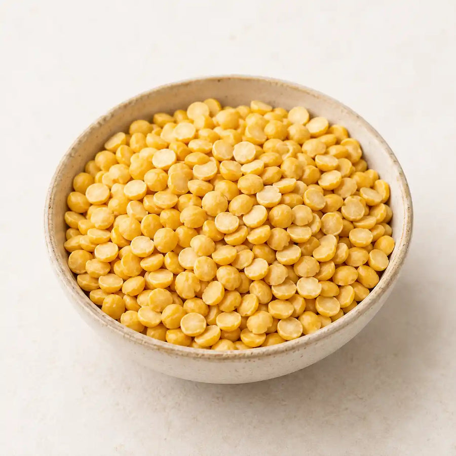 Roasted chana dal, or roasted gram, piled in a small ceramic bowl on a clean light background.