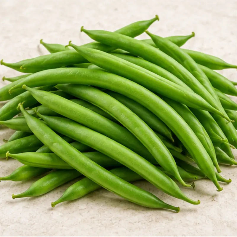 A pile of fresh green snap beans on a light beige textured surface.