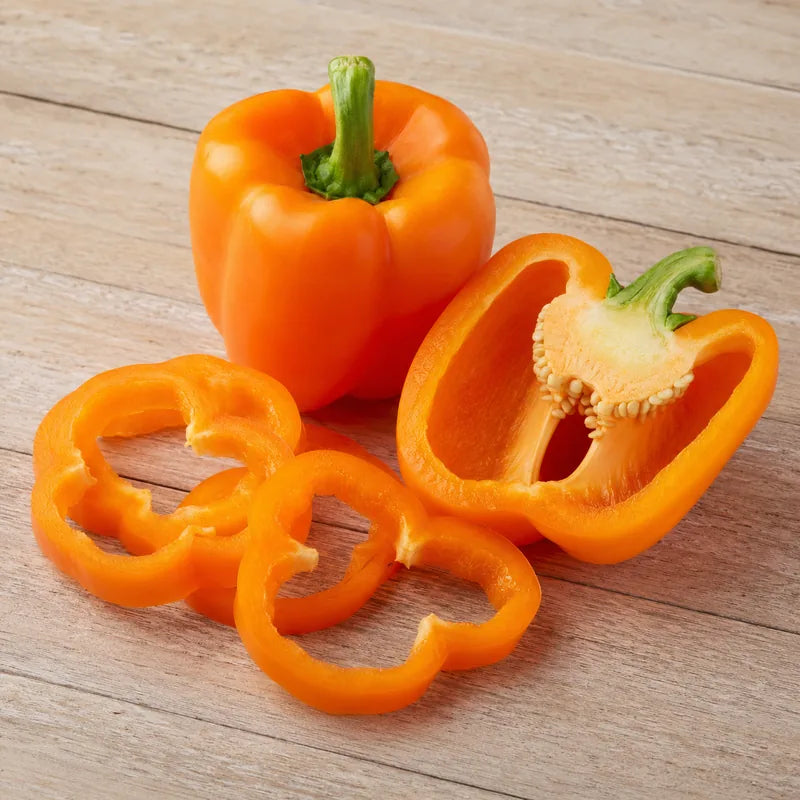 Fresh orange bell pepper shown whole, halved and sliced into rings.